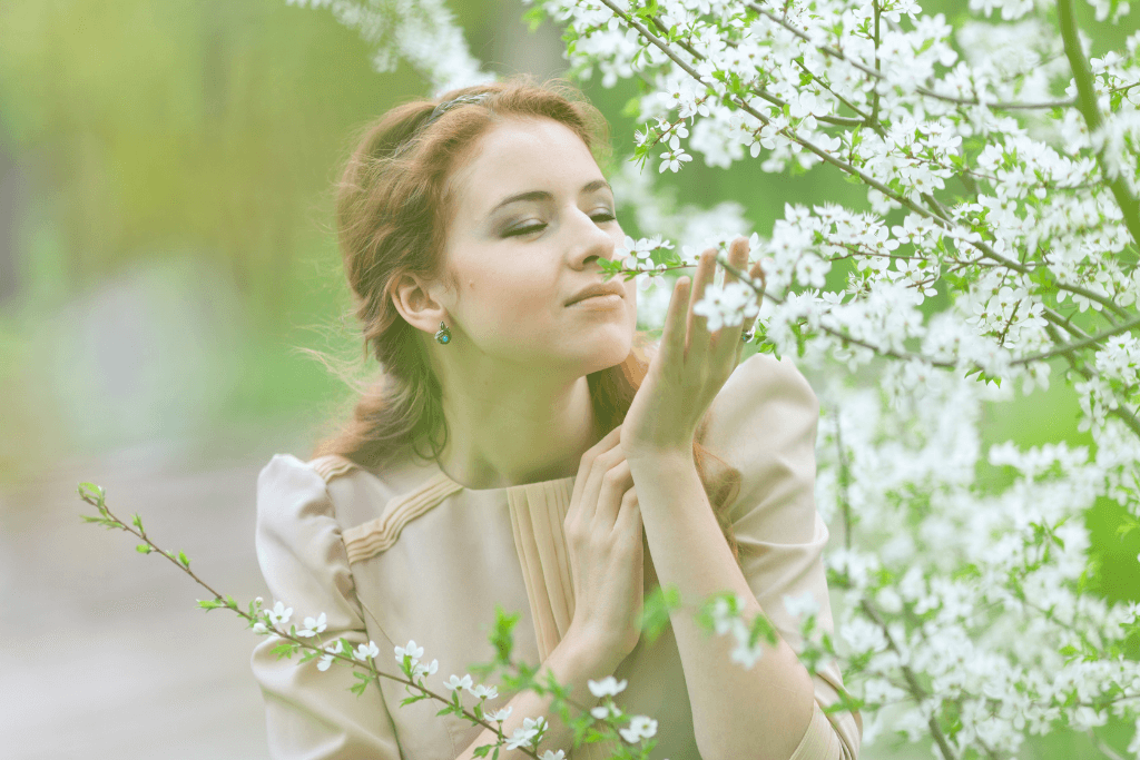 A woman smelling flowers in spring and taking advantage of living a good life