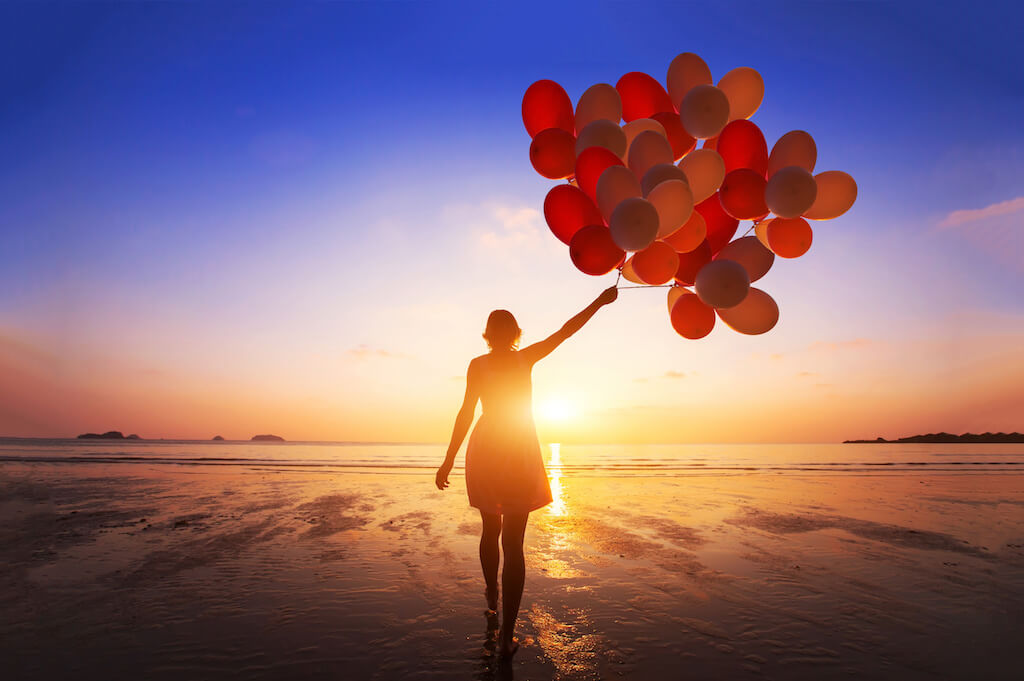 Change your thoughts change your life a woman looking at the horizon letting go of life balloons getting in the way of living life to the full